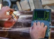 Contrôle non destructif par ultrasons d’une pièce métallique, avec sonde et appareil de mesure portatif pour vérifier la qualité interne du matériau.