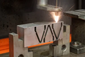 Opération d’électroérosion à fil usinant un bloc métallique, avec gerbe d’étincelles.