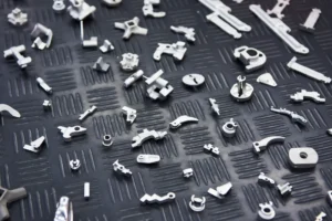 Diverses petites pièces métalliques de micromécanique disposées sur un plateau noir.