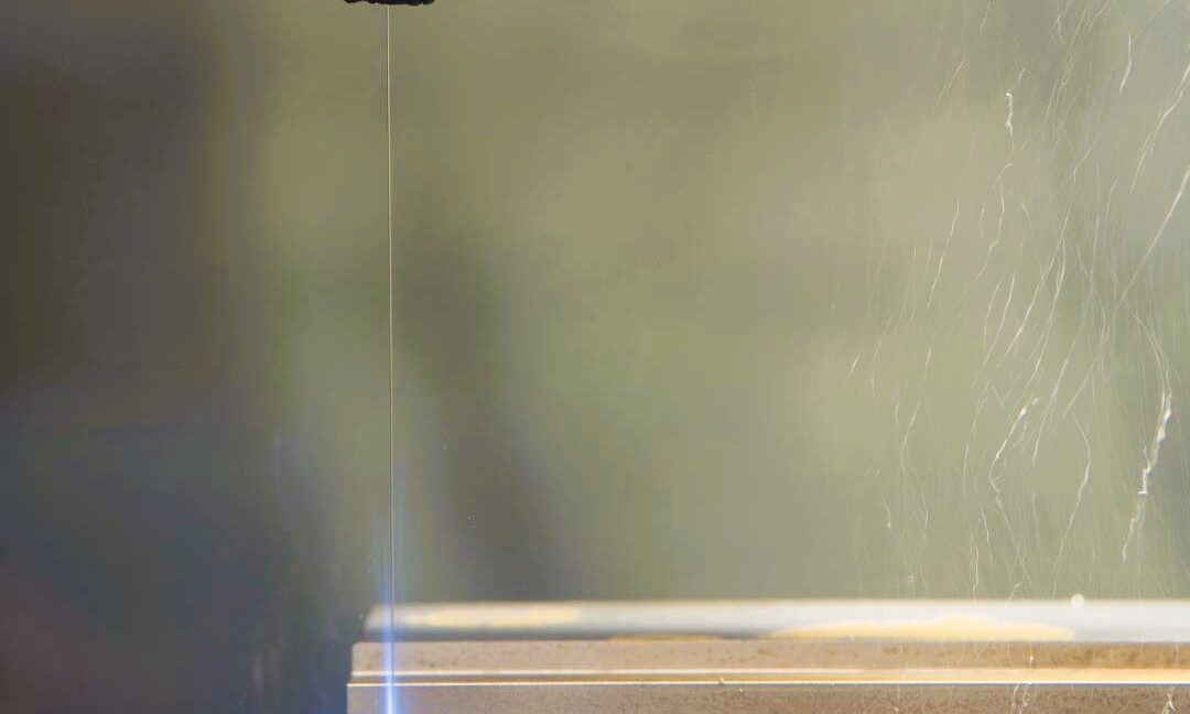 Fil d’électroérosion en action découpant un bloc métallique sur une machine d’usinage de précision.